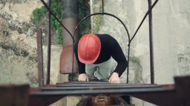 Genç bir işçi merdivenlerden yukarı gidiş