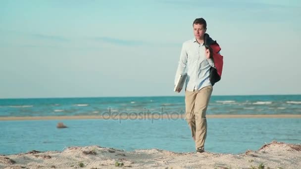 Hombre caminando playa con portátil a mano — Vídeos de Stock