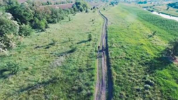 Jovens que pedalam de bicicleta na estrada rural — Vídeo de Stock