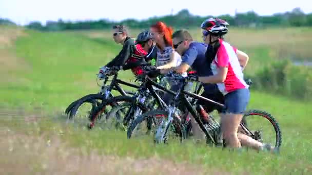 Велогонщики толкают велосипеды вверх по холму — стоковое видео