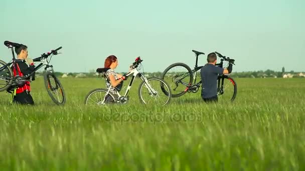 Fietsers dragen van fietsen door hoog gras — Stockvideo