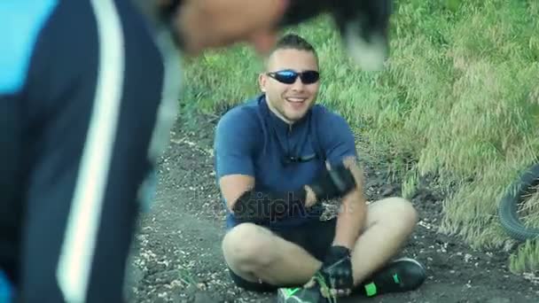 Ciclista sentado en el suelo — Vídeo de stock