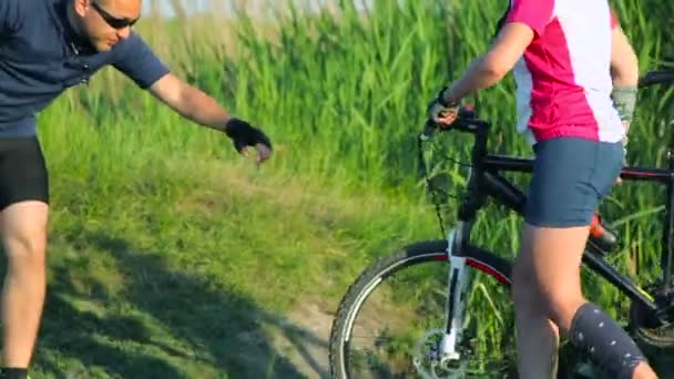 Paar overschrijding van een beek samen met hun fietsen op platteland — Stockvideo