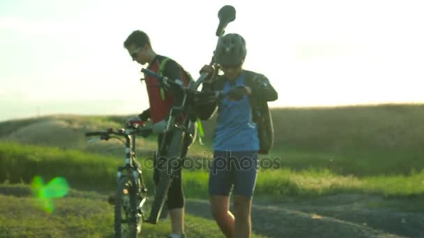 Deux hommes portant leurs vélos — Video