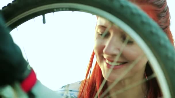 彼女の自転車を修正するを助ける女性 — ストック動画