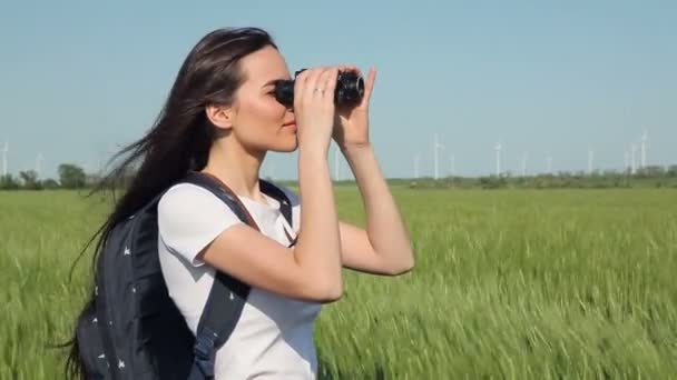 Mujer joven mirando a través de prismáticos — Vídeo de stock
