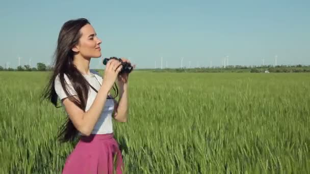 Jeune femme regardant à travers les jumelles — Video