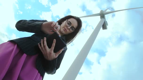 Mujer mirando la tableta cerca del molino de viento — Vídeos de Stock