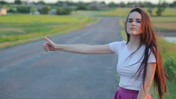 Chica joven tratando de detener el coche en la carretera — Vídeo de stock