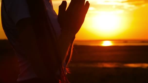 Silhouet van jonge vrouw bidden bij zonsondergang — Stockvideo