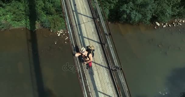 Человек-турист стоит на мосту и машет рукой — стоковое видео