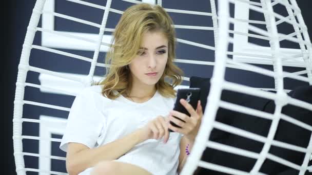 Blond dívka používá její smartphone. — Stock video