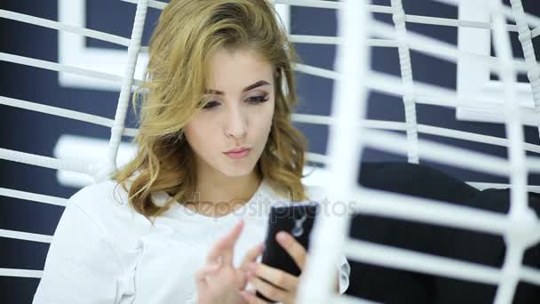 Blond dívka používá její smartphone. — Stock video