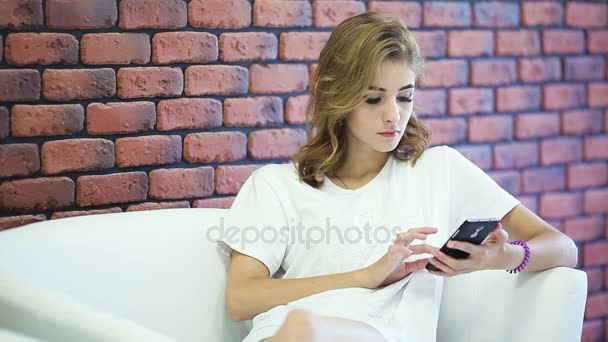 A menina loira usa seu smartphone . — Vídeo de Stock