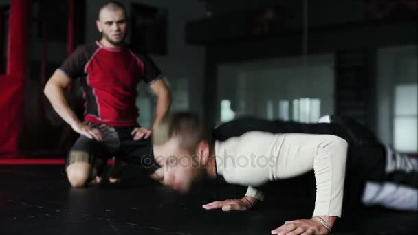 Joven atleta caucásico en ropa deportiva haciendo flexiones — Vídeo de stock