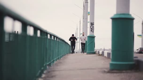 Atletas masculinos corriendo en puente — Vídeo de stock