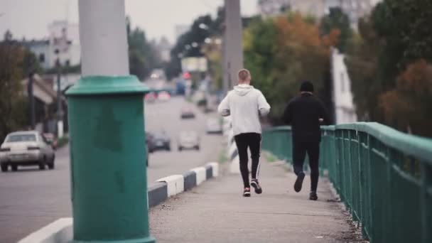 Atletas masculinos corriendo en puente — Vídeos de Stock