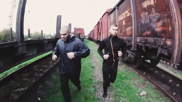 Männer laufen auf der Eisenbahn — Stockvideo