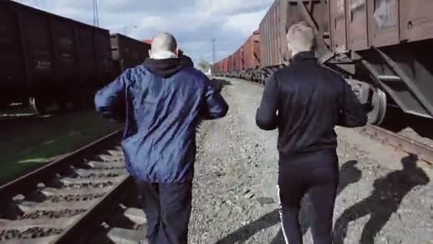 Männer laufen auf der Eisenbahn — Stockvideo