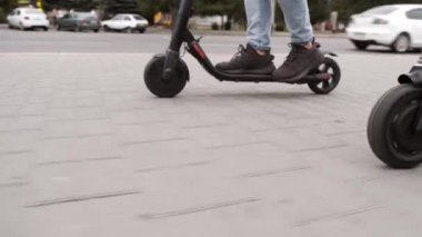 Erkek bacakları geleceğin teknolojisi scooter 'ını sürüyor. Düşük açılı ark atışı.