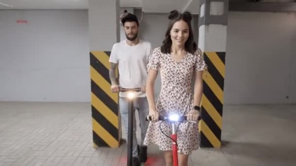 Pareja utiliza transporte alternativo montar e-scooters — Vídeos de Stock