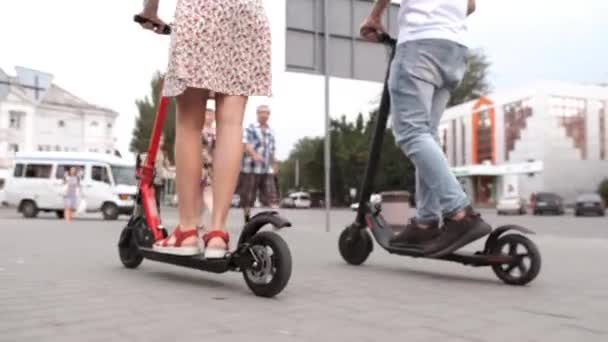 Man and woman legs ride future technology electric scooters — Stock Video