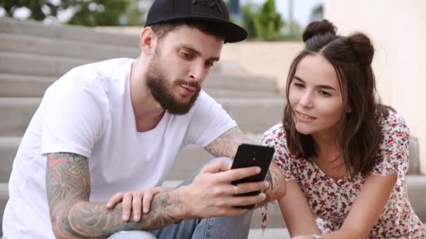 Guy and girl sit on steps with cool scooter standing nearby — Stock Video