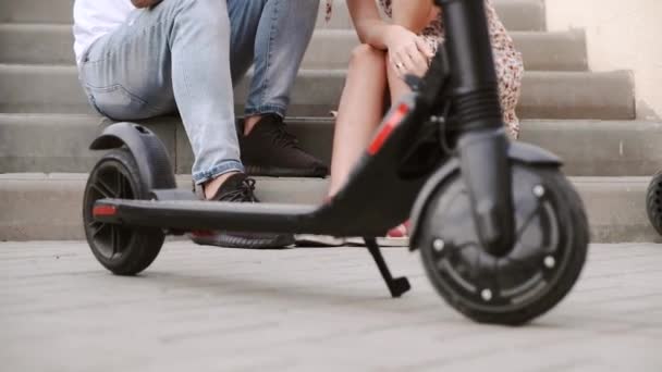 Casal senta-se atrás de scooter elétrico perto baixo ângulo tiro — Vídeo de Stock