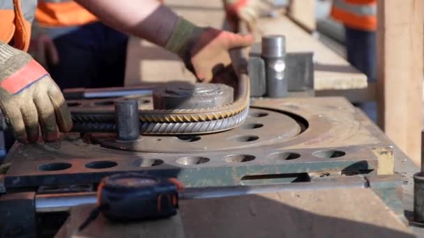 Construction worker hands bend steel reinforcing bar closeup — Stock Video