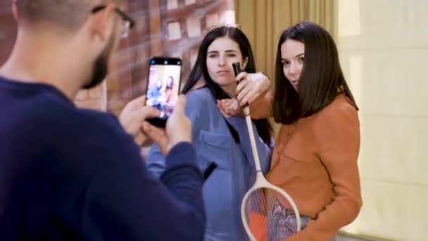 Homem dispara meninas com raquetes em co-working câmera lenta — Vídeo de Stock