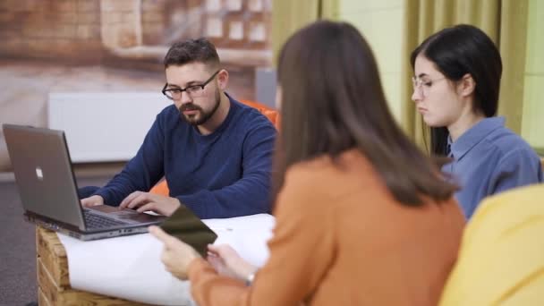 Equipo joven trabaja en una tormenta de ideas en la sala de coworking cámara lenta — Vídeo de stock