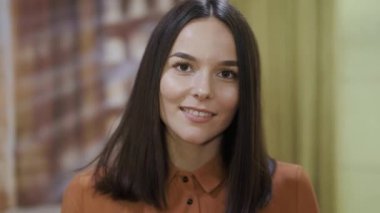 Genç iş kadını modern geniş çalışma alanında gülümsüyor