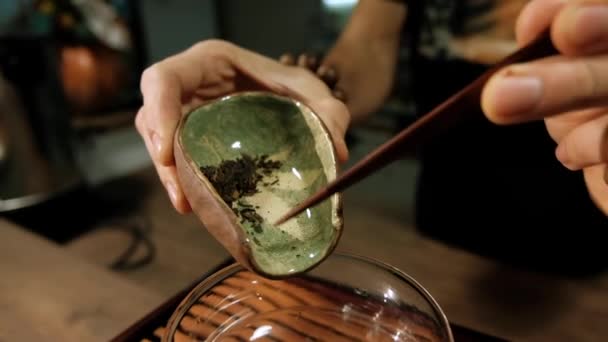 Az ember poszt-fermentált teát tölt tálból üvegbögrébe — Stock videók