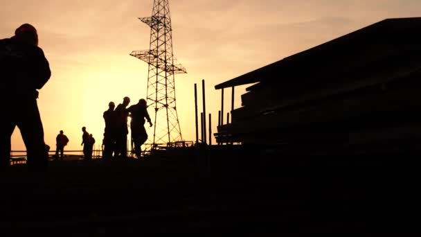 Siluetter av arbetstagare på en byggarbetsplats — Stockvideo
