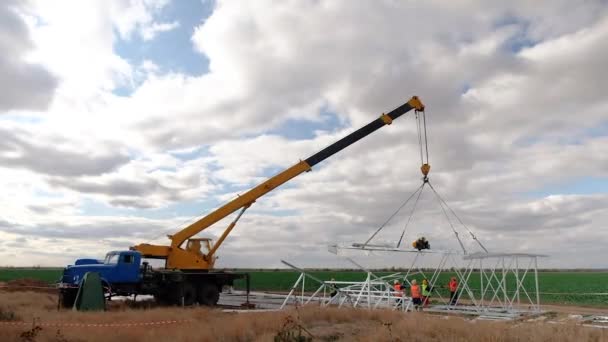 Kamyon vinci kullanan yükleyiciler elektrik desteği topluyor. — Stok video