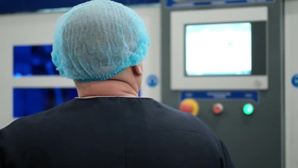 Ingeniero de fábrica en un tocado especial controla la tecnología de producción utilizando un panel de control de automatización . — Vídeos de Stock