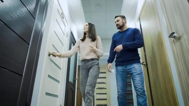 Una donna e un uomo scelgono porte interne in un supermercato di beni per la casa e materiali da costruzione . — Video Stock