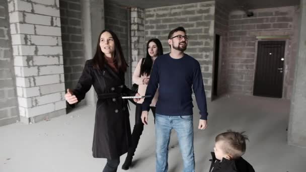 Realitní makléř potká mladou rodinu, aby demonstroval nový domov. — Stock video