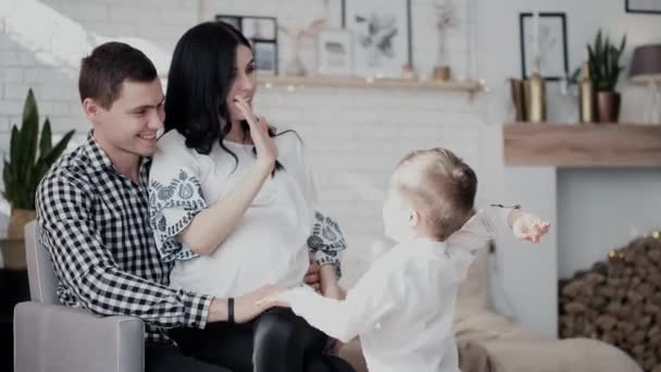 Pequeño chico da alta cinco y marido abraza embarazada morena — Vídeos de Stock