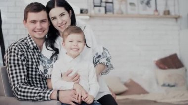 Güzel bayan kucaklar küçük oğlu koca dizlerinin üstünde oturur