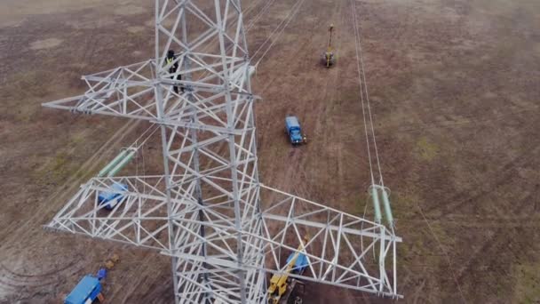 Электрик на туше энергопередающей башни на земле — стоковое видео