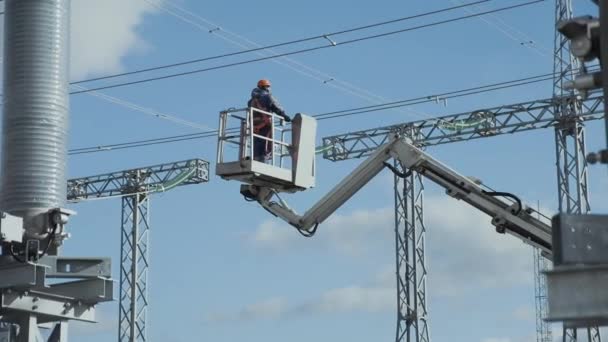 Laborer lifts up in truck crane basket to high voltage wires — Stock Video