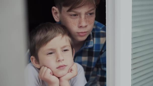 Kinderen vervelen zich door het raam tijdens quarantaine. — Stockvideo