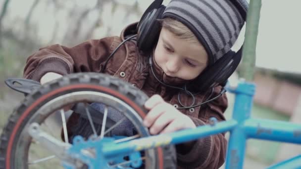 Un garçon de 5 ans s'occupe de son vélo pour enfants . — Video