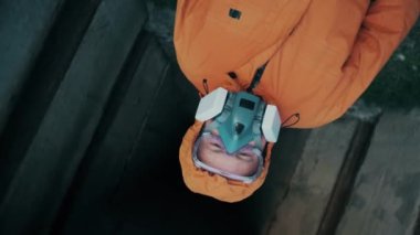 Solunum cihazlı ve özel tulumlu bir adam beton bir sığınaktan çıkıyor.