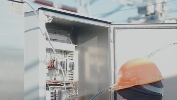 Bir erkek elektrikçi elektrik kablosuyla santralde çalışıyor.. — Stok video