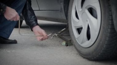 Bir arabanın tekerleğini değiştirmek için mekanik asansör kullan