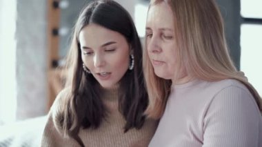 Anne ve kızı fotoğraflara bakıyor.