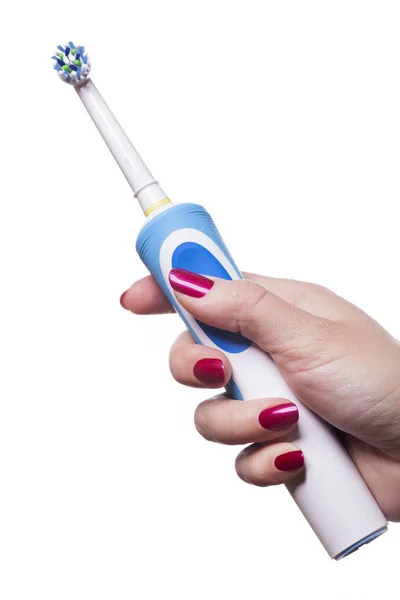 Hand holds electric toothbrush against white — Stock Photo, Image