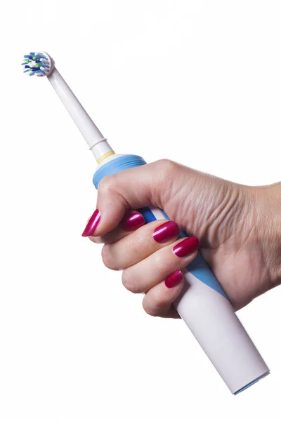 Ręką trzyma elektryczna szczoteczka do zębów przeciw biały — Zdjęcie stockowe